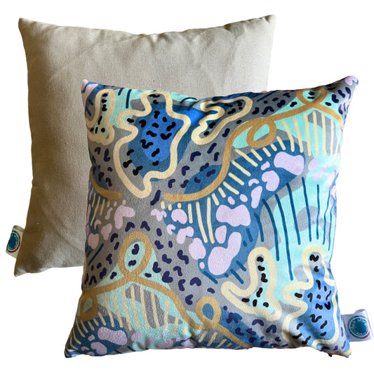 The front and back of a colourful abstract cushion. The front features abstract shapes and lines in shades of blue, green and yellow.