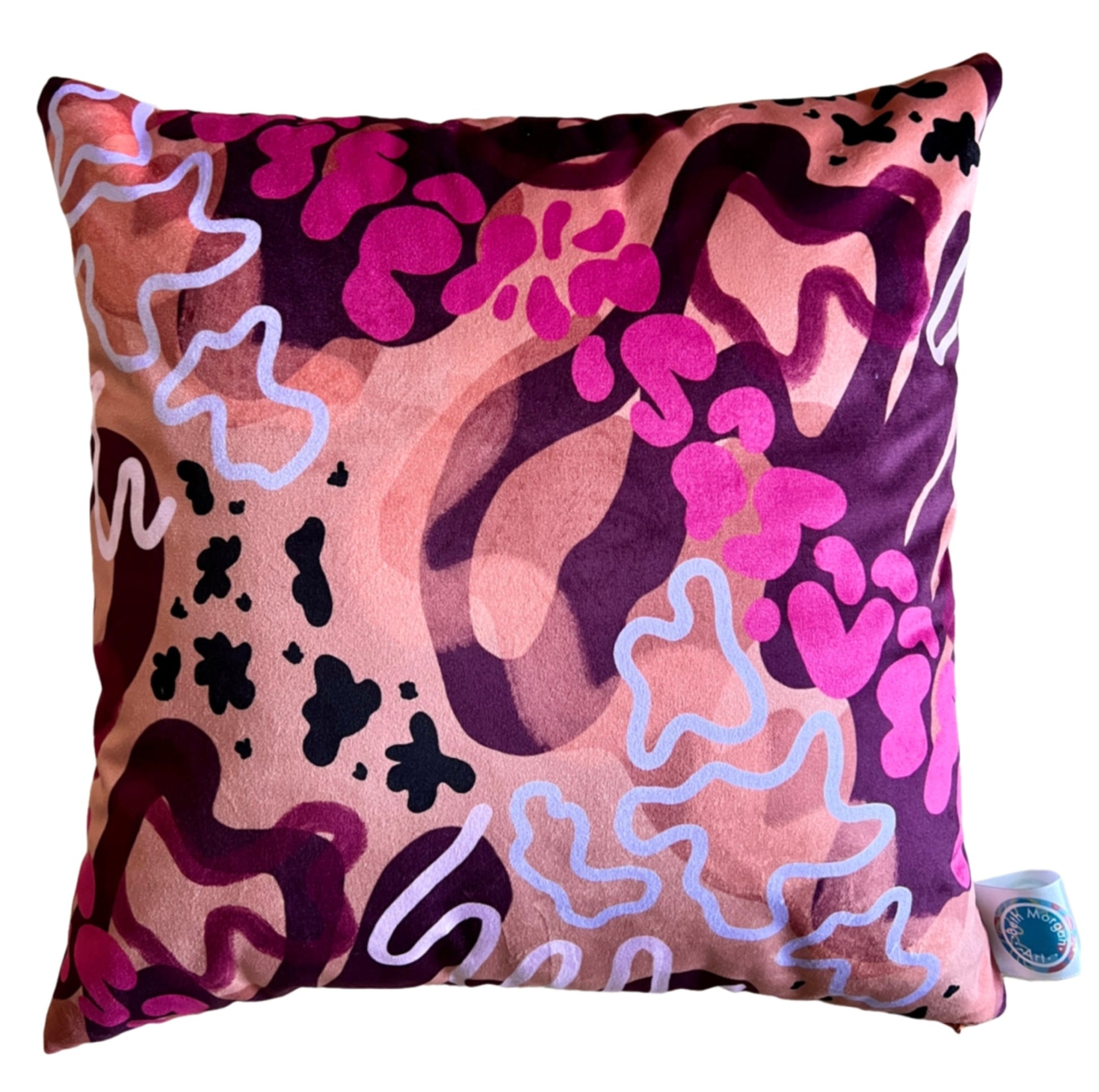 The front of the Sunset Cushion by Beth Morgan Art featuring bright pink print across an orange background with abstract shapes of dark purple.